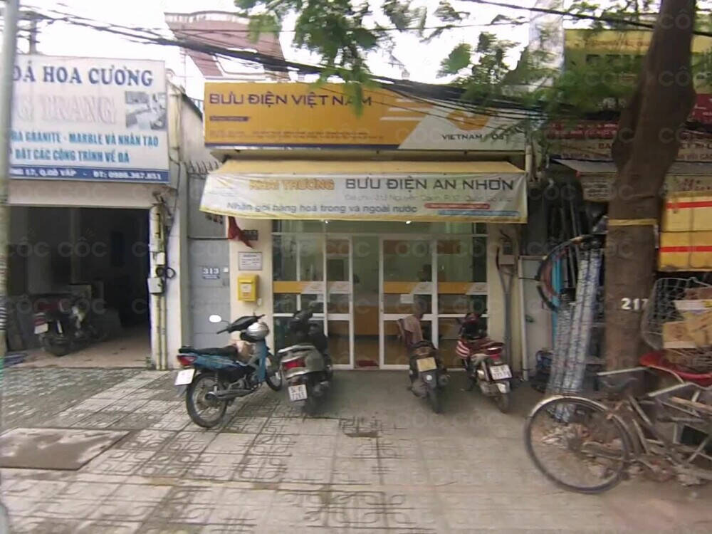 Một góc nhìn từ bên ngoài Bưu Điện An Nhơn, hiển thị biển hiệu và lối vào chính